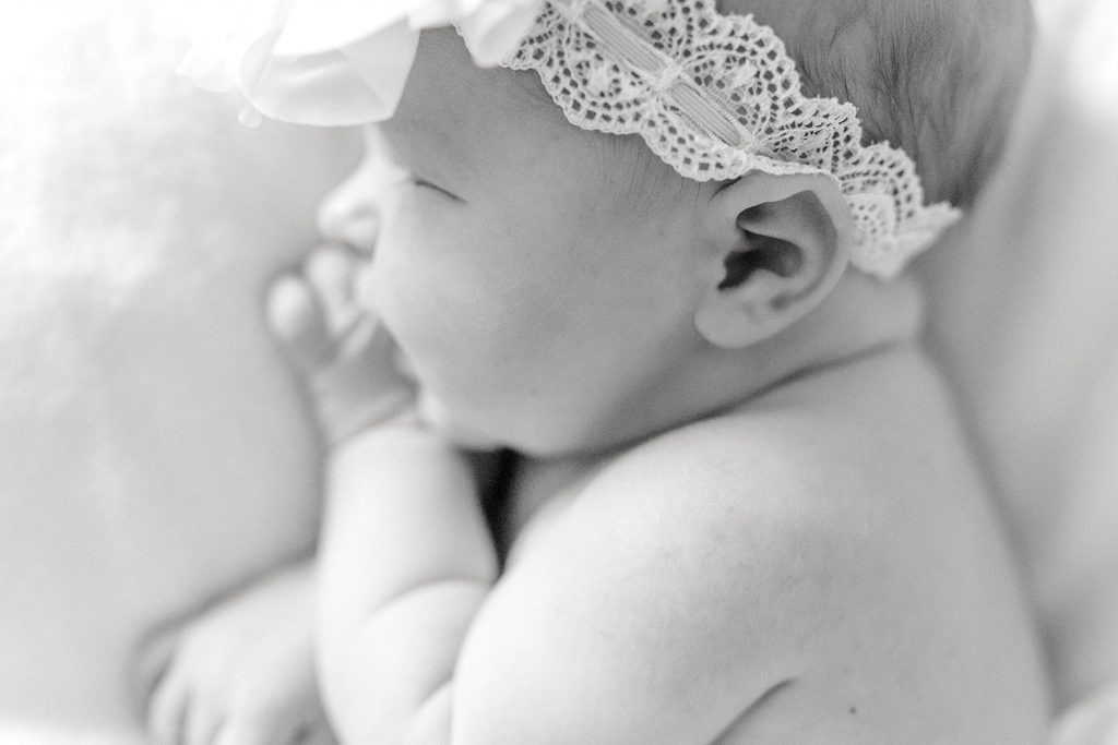 BW close up of newborn baby girl ear and lacy headband