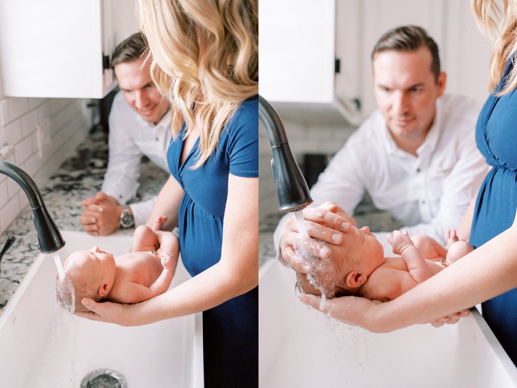 Parents bathing newborn baby in kitchen sink during their lifestyle newborn session 