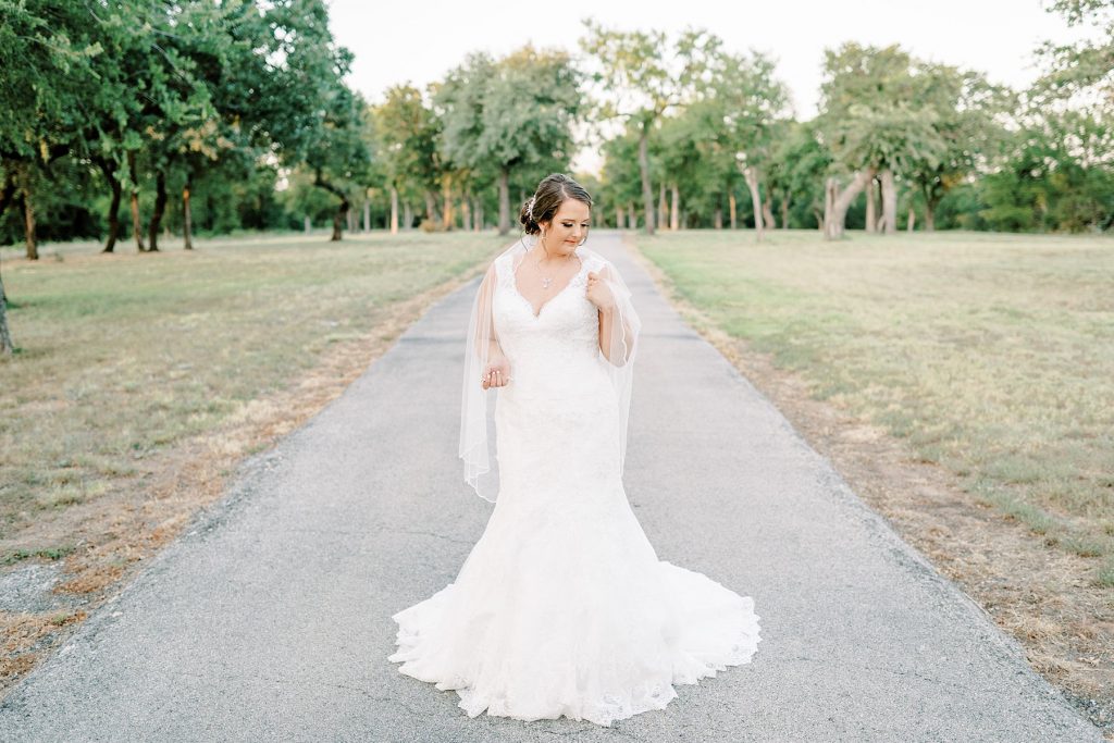 Bride standing in middle of road in wedding gown at Wildcatter Ranch