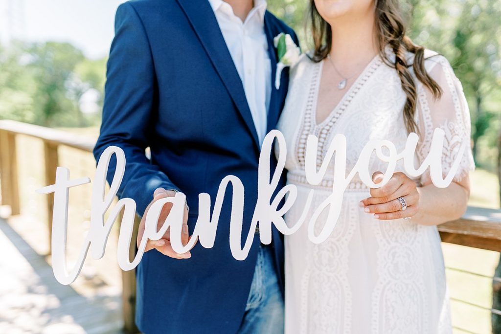 bride and groom holding 'thank you' sign at Texas elopement