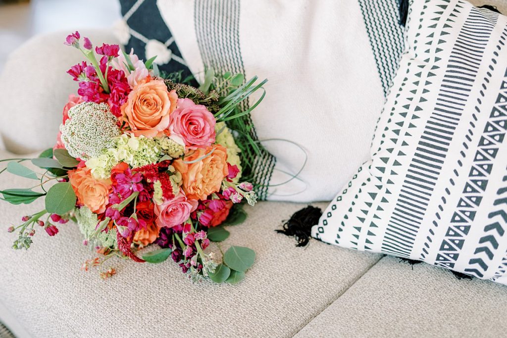 Floral bouquet laying on couch next to pillows