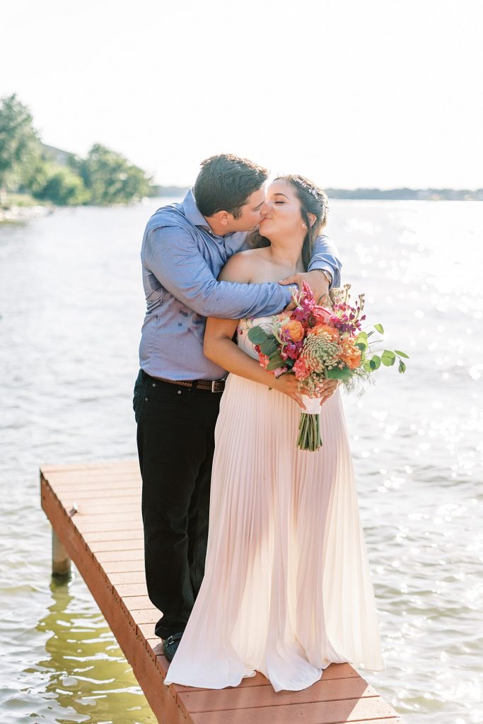 Bride and groom kissing on dock for Lake Granbury Elopement