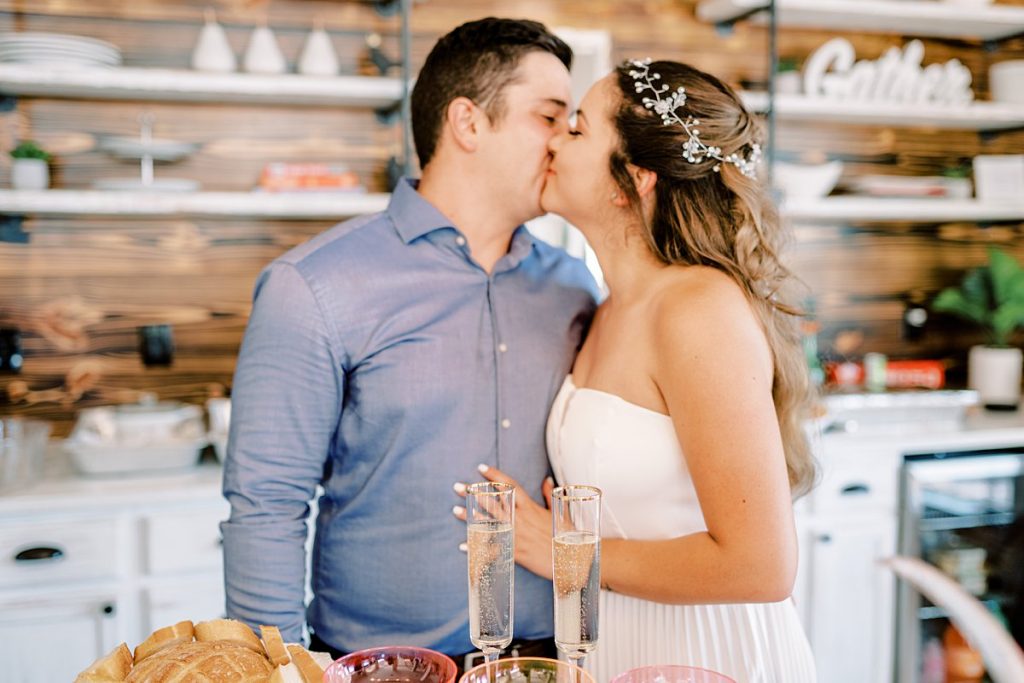 Bride and groom kissing in front of champagne glasses