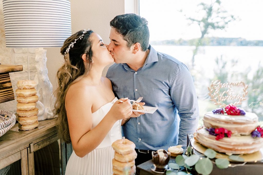 Bride and groom kissing at cake cutting