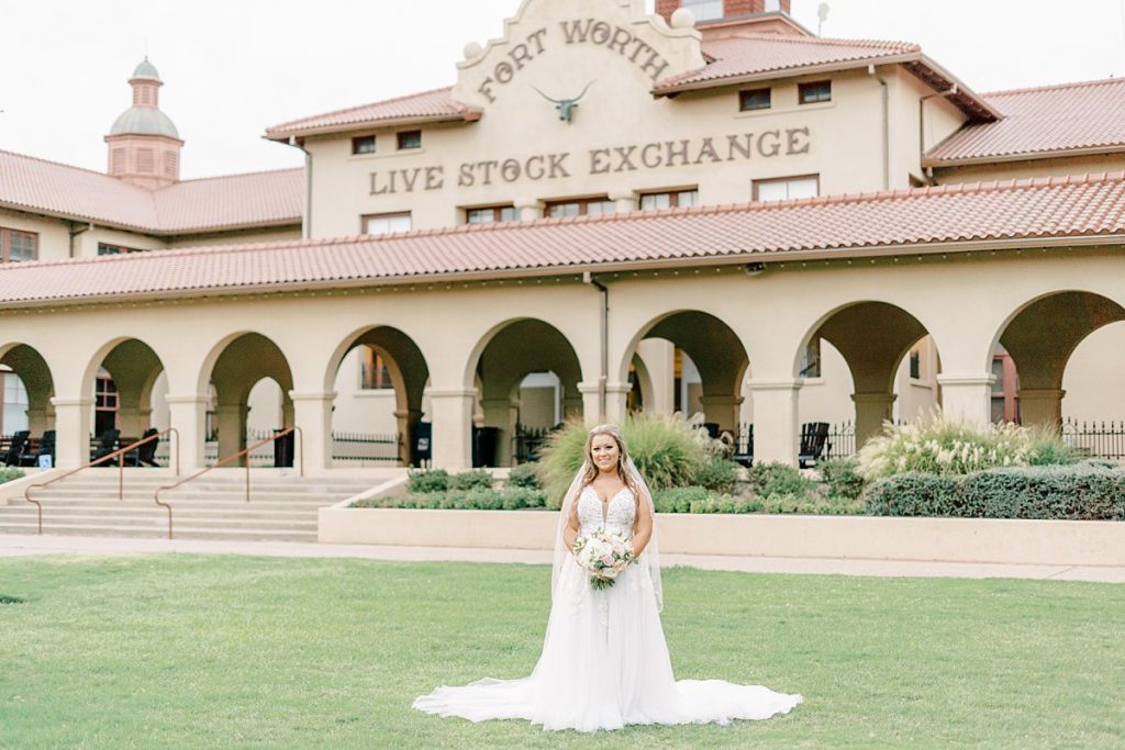 Bride smiling standing in front of Fort Worth Live Stock Exchange