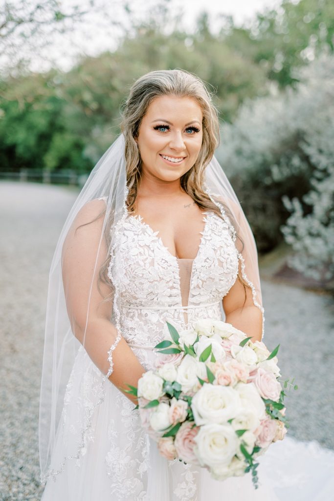 Bride smiling holding white rose bridal bouquet in Fort Worth Stockyards bridal session