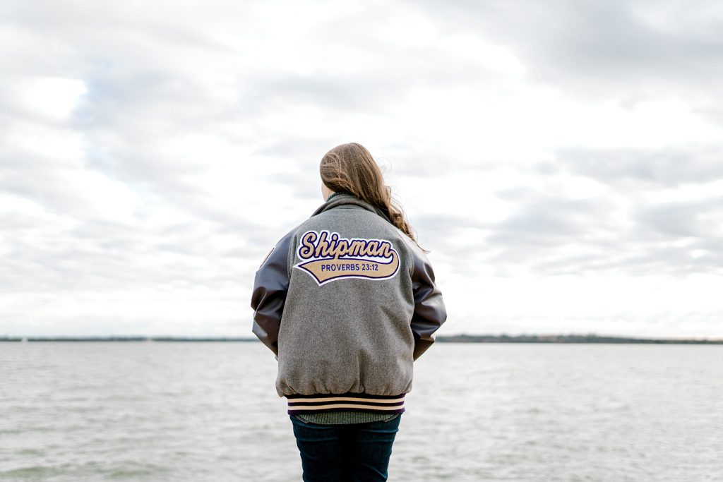 senior girl in letterman jacket with proverbs 23:12 on back| Timber Creek Senior Session