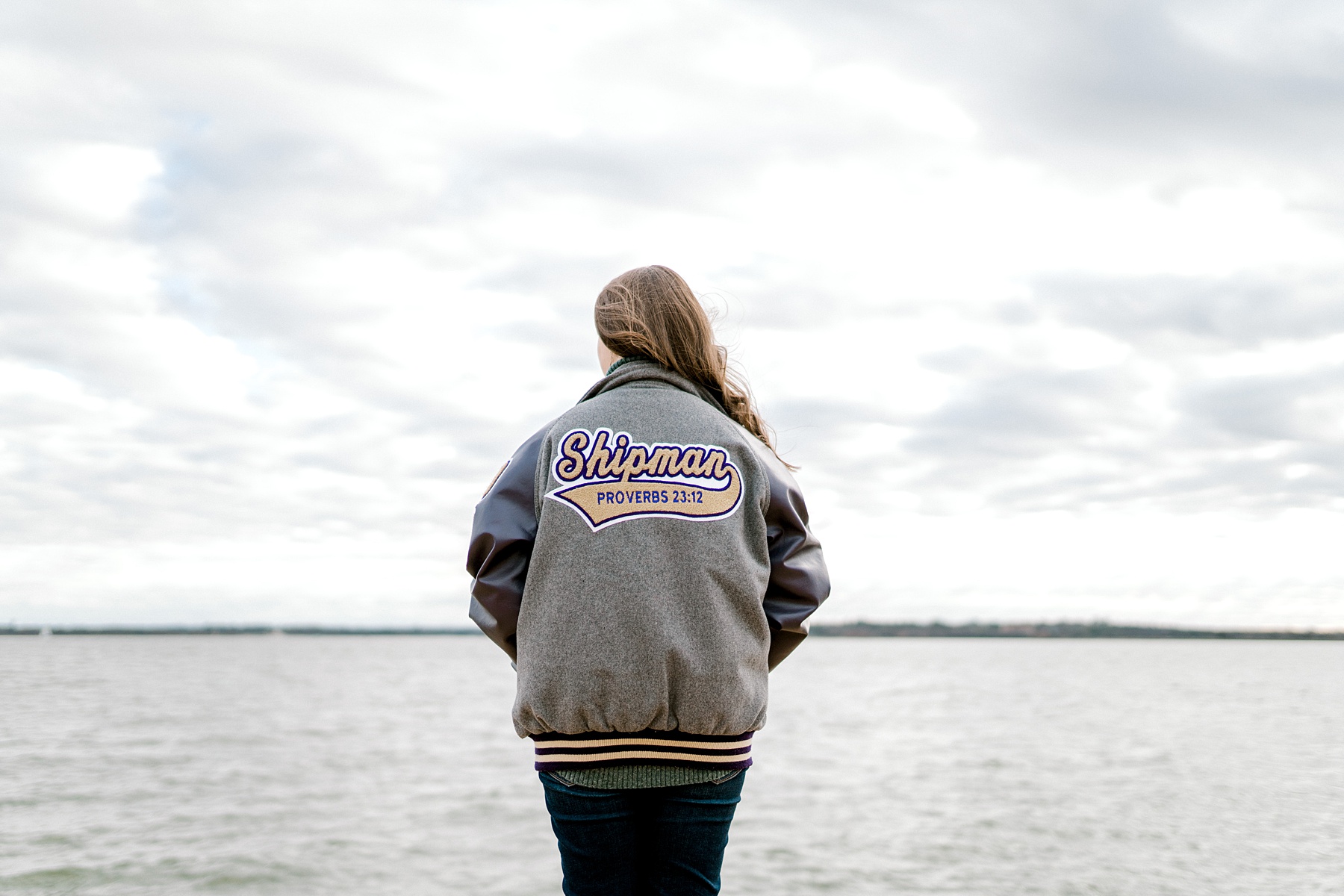 senior girl in letterman jacket with proverbs 23:12 on back