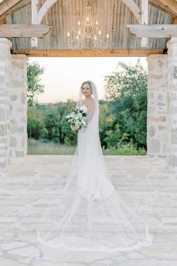 Bride standing under chandelier at Five Oaks Farm Texas bridal session