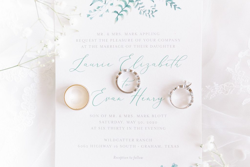 wedding rings on white wedding invitation