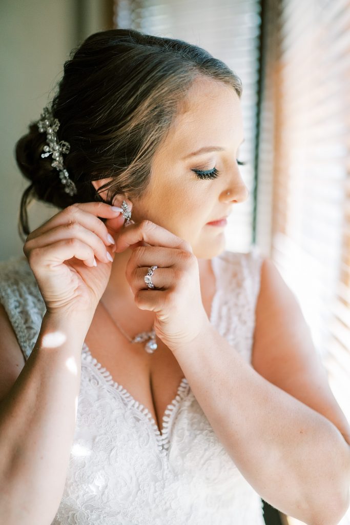 Bride putting earring on