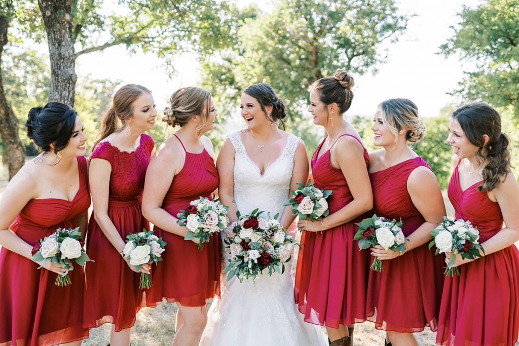 Bride laughing with bridesmaids in red