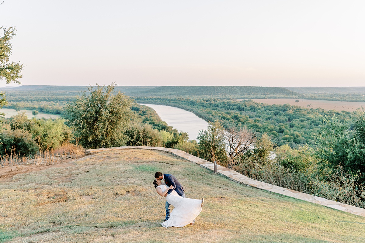 groom dips bride for kiss at wildcatter ranch wedding
