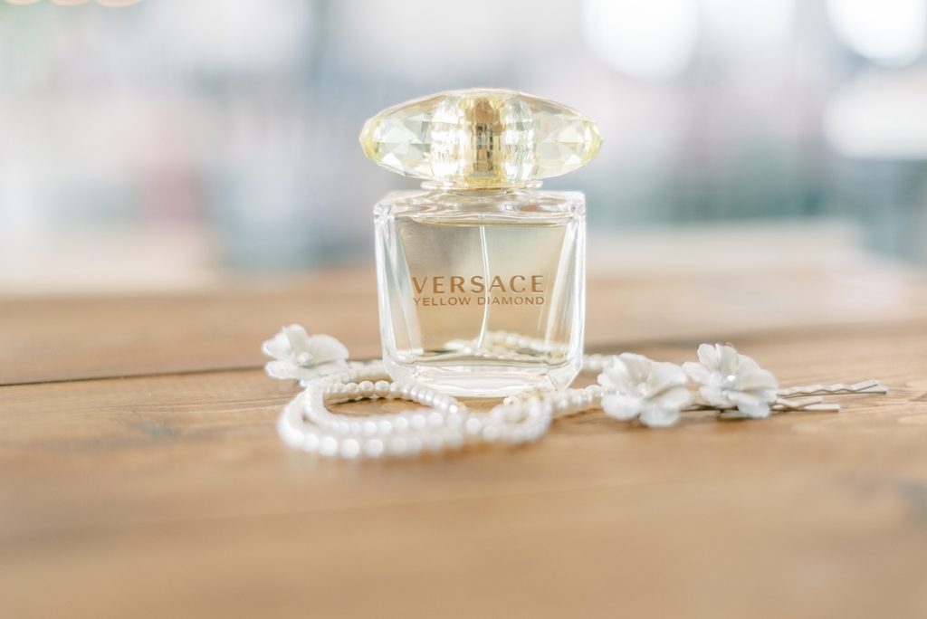 Versace perfume body sitting with pearl necklace