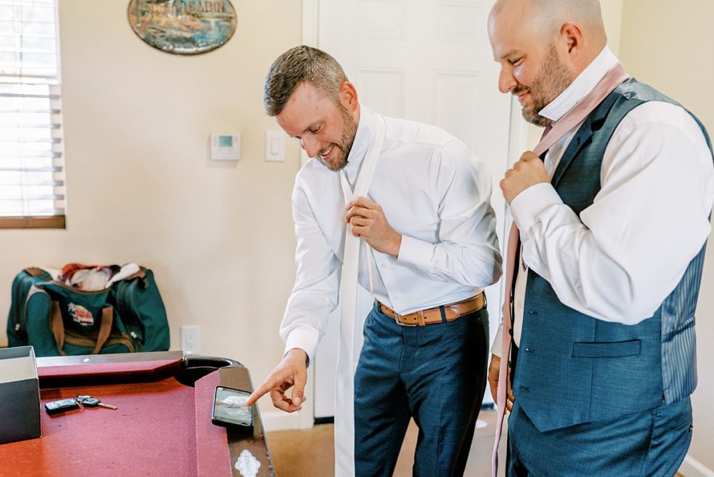 groom and groomsman tying their ties