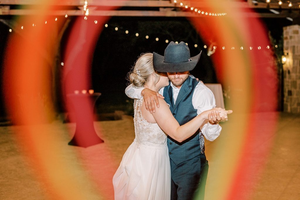 Couple dancing under string lights at the orchard wedding venue 