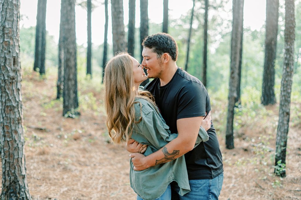 Couple kissing in the woods in LBJ Grasslands anniversary session