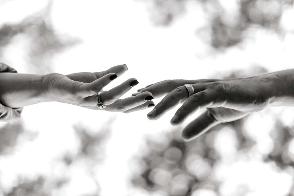 BW husband and wife hands reaching for each other
