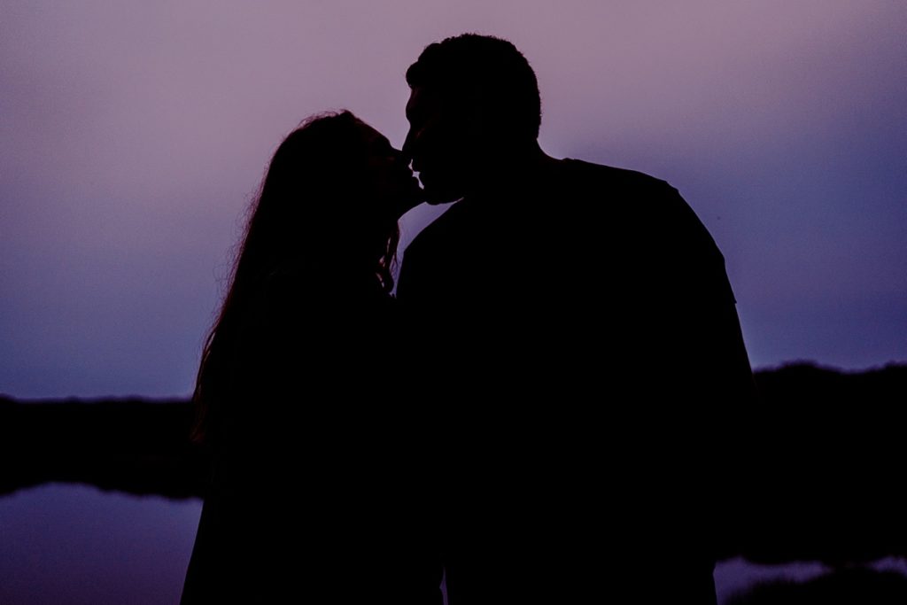 silhouette of couple kissing in front of LBJ Grasslands lake