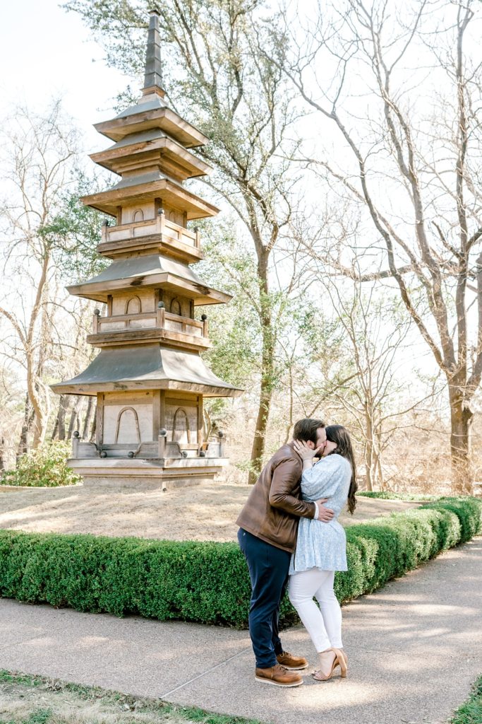 Couple kissing in Fort Worth Botanical Gardens engagement