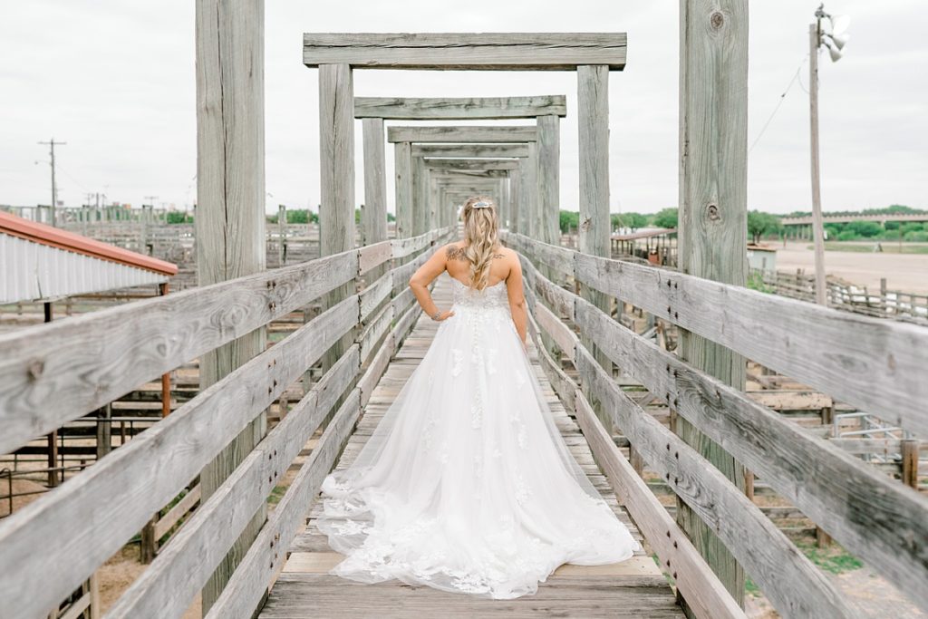 Bride standing on bridge at ranch in Fort Worth Stockyards bridal session