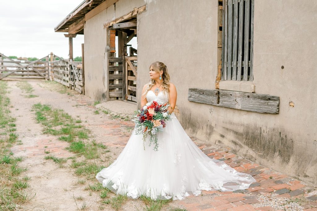 Bride standing near horse stalls