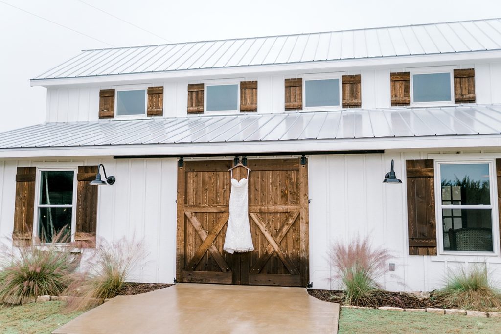 wedding gown hanging on barn doors Five Oaks Farm