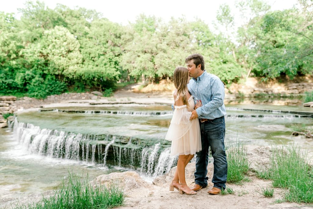 guy kissing girl on forehead at Airfield Falls Texas engagement