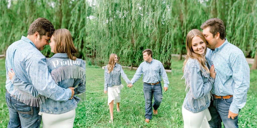 engaged couple standing together under willow tree