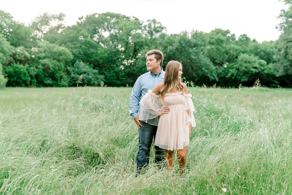 Couple standing in field in airfield falls Texas engagement