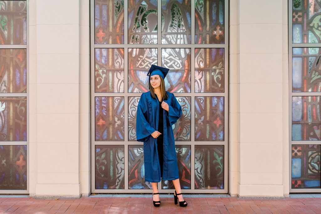 Graduate standing in front of stained glass window Texas senior session
