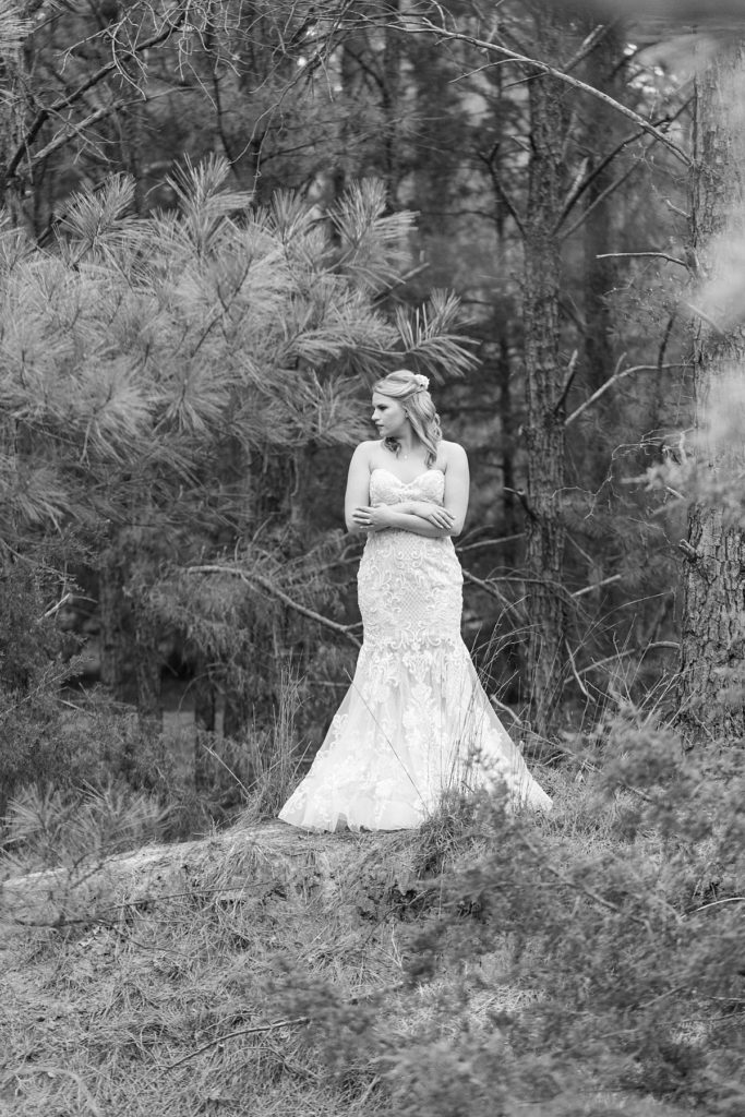 BW | Bride standing in woods holding bouquet in outdoor bridal session Texas