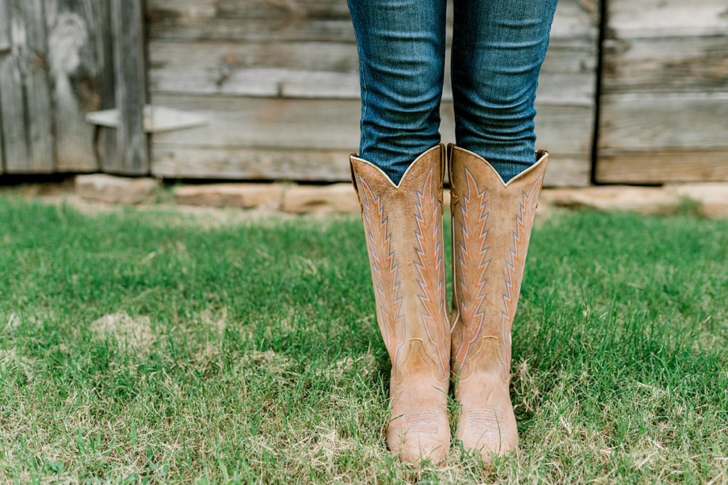 girl standing in cowboy boots in grass