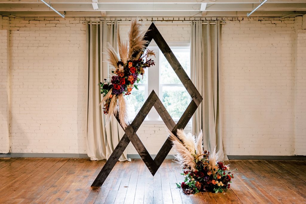 modern diamond wedding arch with vibrant wintery florals at the Brik wedding venue