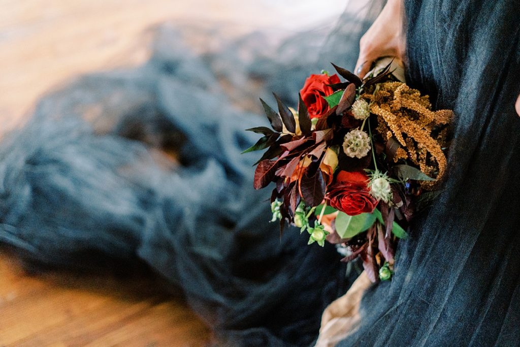 deep, vibrant winter wedding bouquet with black wedding gown