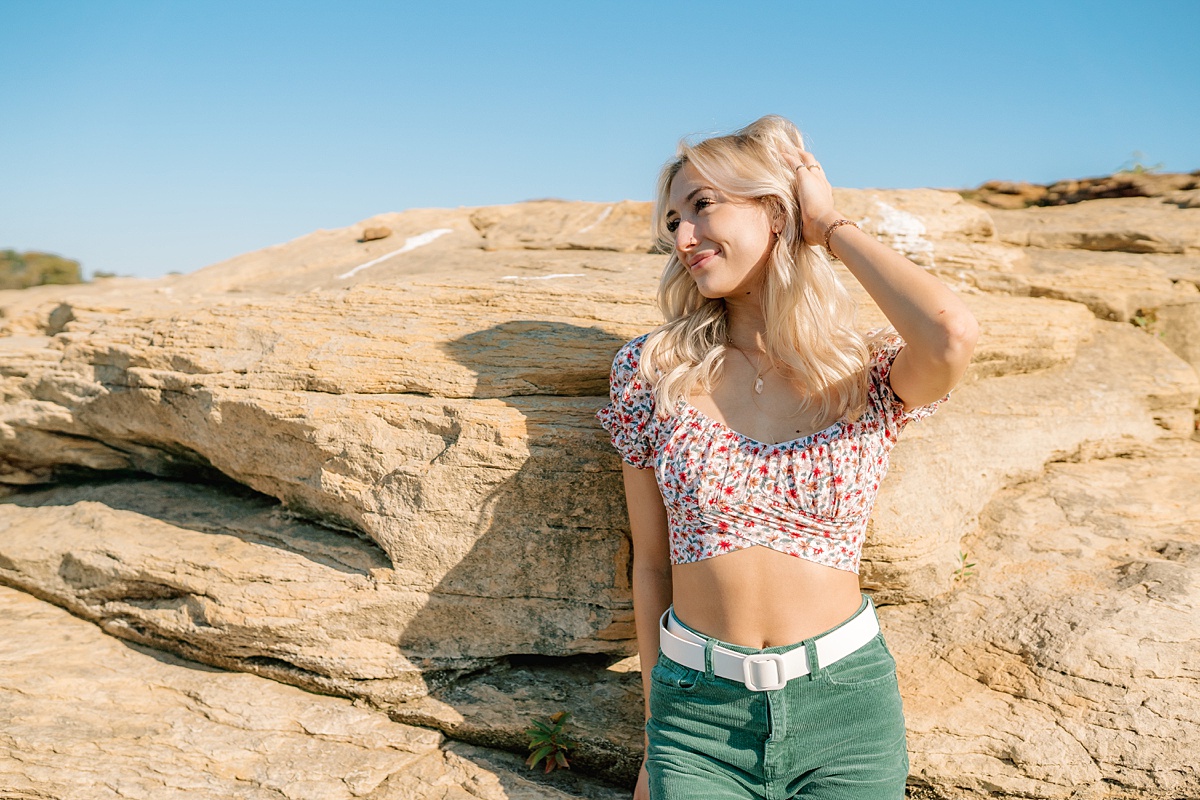 blonde girl leaning against rock
