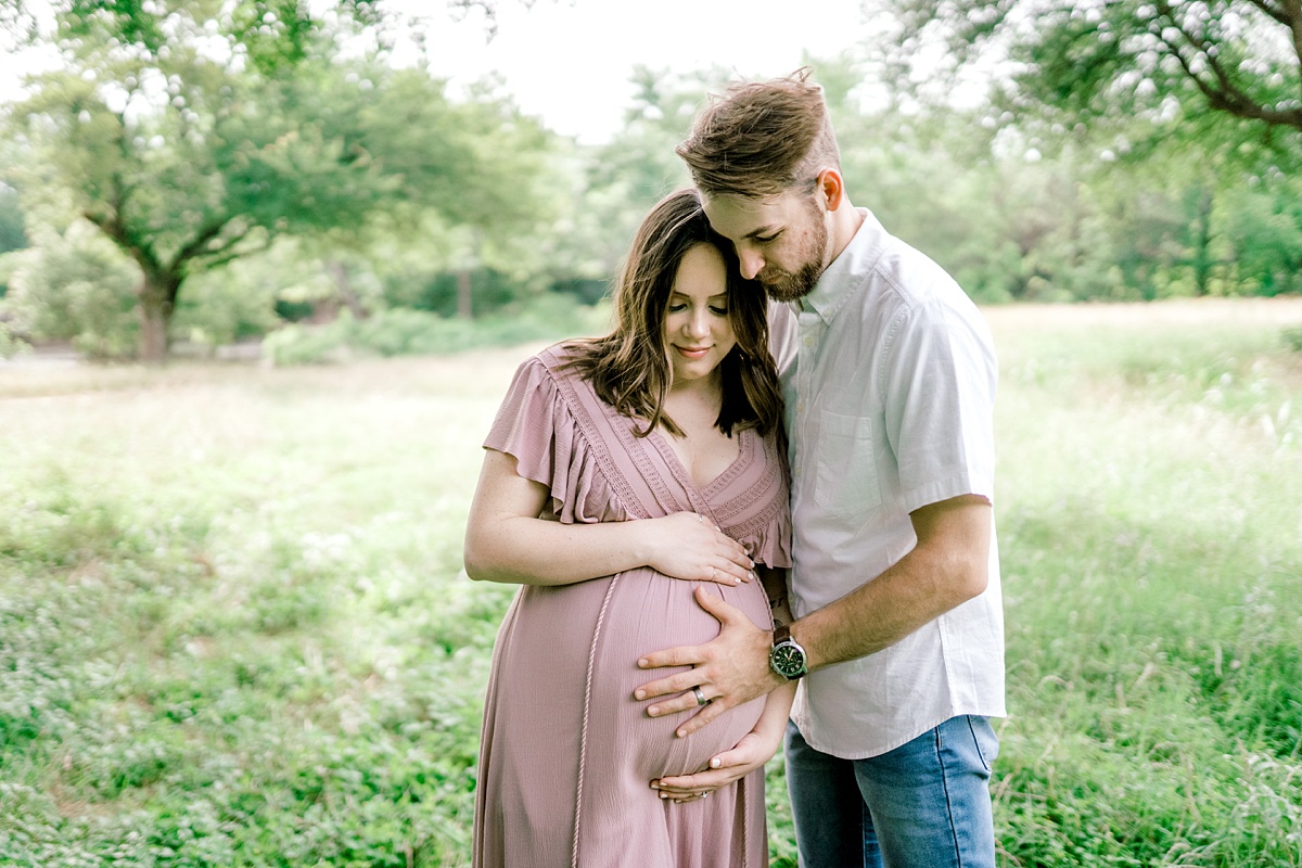 expecting mom and dad holding pregnant belly in Texas maternity session
