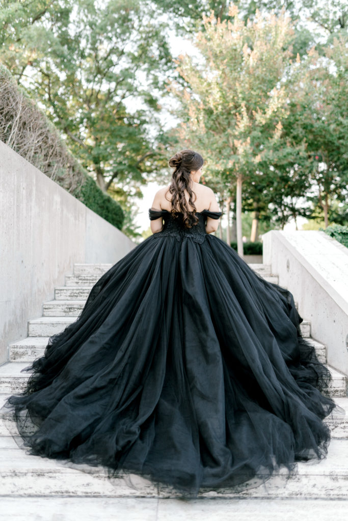 bride in black ball gown on stairs