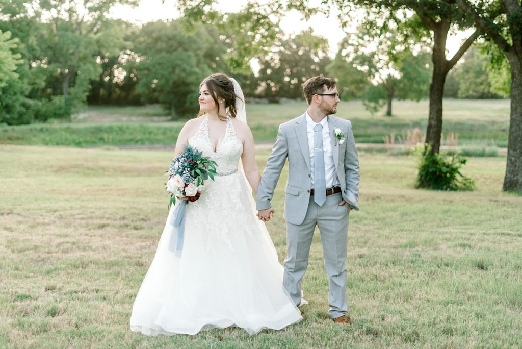 bride and groom holding hands in field The Hamptons at Weatherford Texas wedding