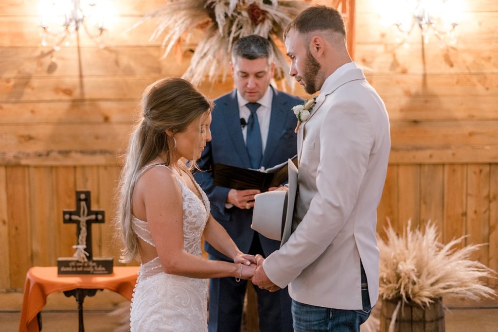 bride and groom exchange vows at alter