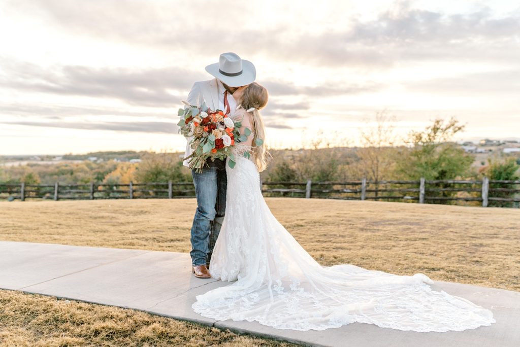 bride and groom kissing on sidewalk