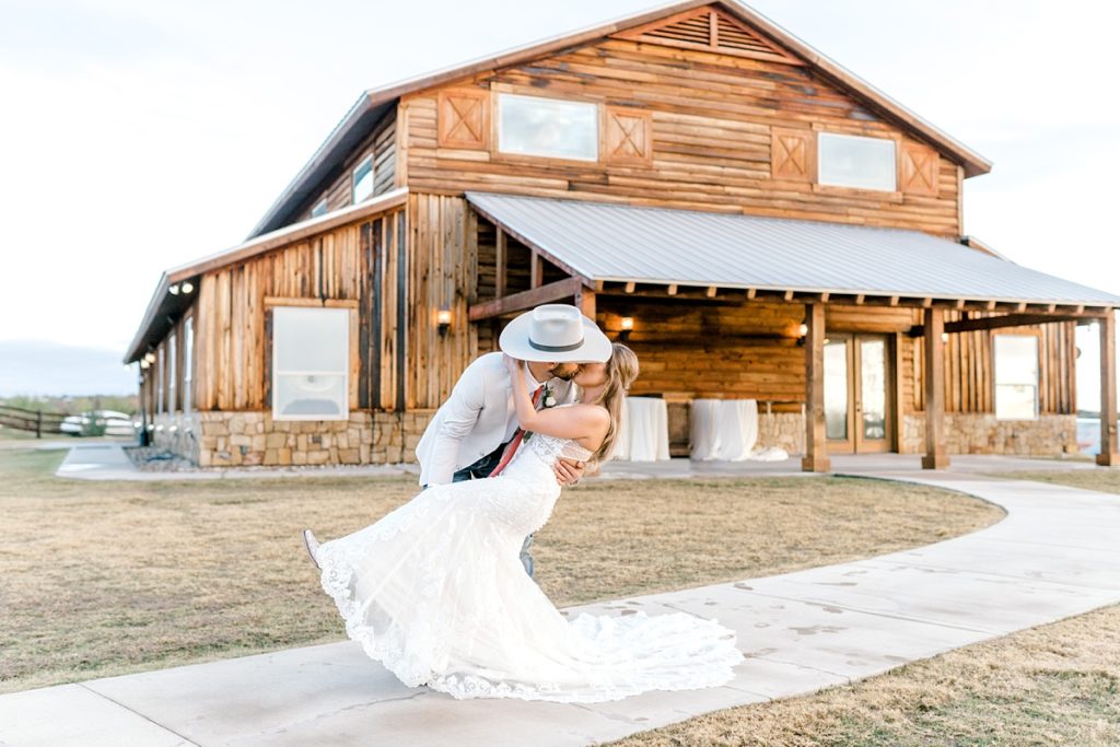 groom dips bride down to kiss at Diamond H3 Ranch wedding Texas